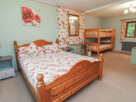 A bedroom with a double bed and a bunk bed at West Down Country House in South Molton