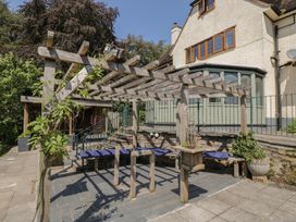 An outdoor seating area with a pergola and benches at West Down Country House in South Molton