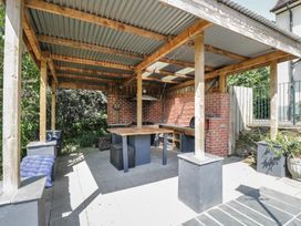 An outdoor kitchen shelter with a table and benches at West Down Country House in South Molton