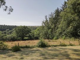 A green field with trees and a fence at West Down Country House South Molton