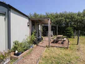 An outdoor area with a hut, table, and chairs at Daisy Shepherd's Hut in South Molton