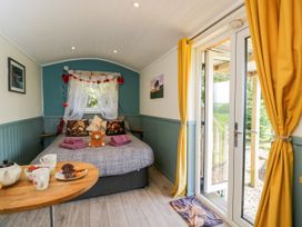 A bedroom with a bed and coffee table at Daisy Shepherd's Hut in South Molton