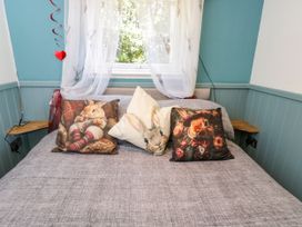 A bed with decorative pillows at Daisy Shepherd's Hut in South Molton