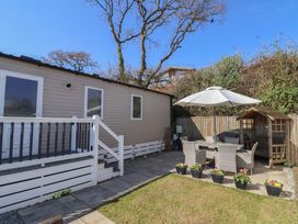 An outdoor seating area with a table, chairs, and umbrella at Bordeaux Ladram Bay Otterton