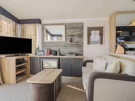 A living room with a television and sofa at Bordeaux Ladram Bay Otterton