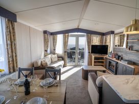 A living room with a sofa and dining table at Bordeaux in Ladram Bay Otterton