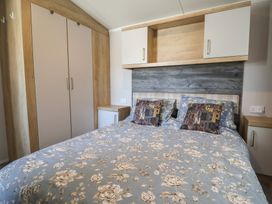 A bedroom with a bed and wardrobe at Bordeaux in Ladram Bay Otterton