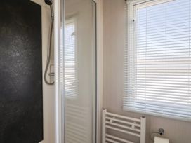 A bathroom with a shower and towel rack at Bordeaux Ladram Bay Otterton