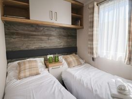 A bedroom with twin beds and a nightstand at Bordeaux in Ladram Bay Otterton
