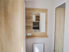 A bedroom with a mirror and shelves at Bordeaux Ladram Bay Otterton