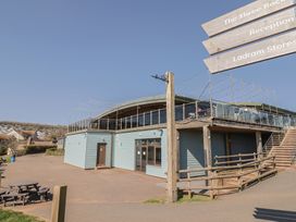 A building with a terrace and seating area at The Three Rocks in Ladram Bay Otterton