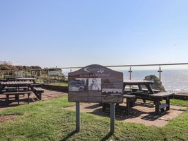 An outdoor area with picnic tables and an information sign at Bordeaux in Ladram Bay Otterton