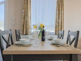A dining room with a table set for a meal at Bordeaux in Ladram Bay Otterton