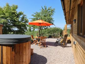 An outdoor space with a hot tub and seating area at Nelli Lodge at Mile End, Crediton