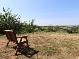 A bench with a view of fields and trees at Nelli Lodge at Mile End Crediton