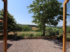 A view from a garden with a chair and tree at Nelli Lodge at Mile End, Crediton