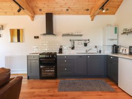 A kitchen with a countertop, sink, oven, and refrigerator at Nelli Lodge at Mile End, Crediton