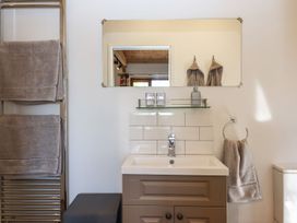 A bathroom with a sink and mirror at Nelli Lodge at Mile End in Crediton