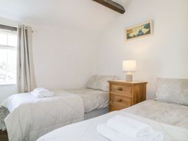 A bedroom with two beds and a lamp at Cottage 2 in Keswick