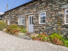 An exterior view of a stone cottage with greenery at Cottage 2 Keswick