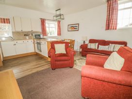 A living room with kitchen area and seating at Cottage 3 in Keswick
