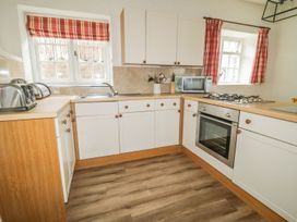 A kitchen with a sink, stove, and microwave at Cottage 3 in Keswick