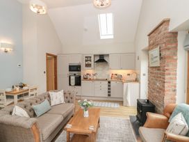 A living room with a kitchen area and dining table at Bumble Bee Lodge in Filey
