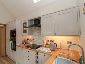 A kitchen with cabinets and a cooker at Bumble Bee Lodge in Filey