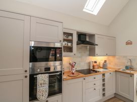 A kitchen with cabinets and appliances at Bumble Bee Lodge in Filey