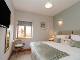 A bedroom with a bed and television at Bumble Bee Lodge in Filey