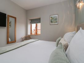 A bedroom with a bed, mirror and television at Bumble Bee Lodge in Filey