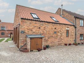 A brick building with a door and roof at Bumble Bee Lodge in Filey