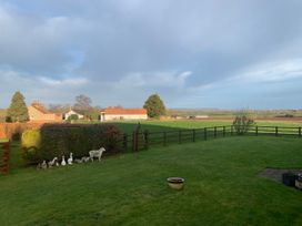 A garden with a fence and ducks at Bumble Bee Lodge in Muston
