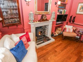 A living room with a fireplace and sofa at The Old Vicarage in Carmarthen