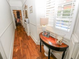 A hallway with a console table and lamp at The Old Vicarage in Carmarthen