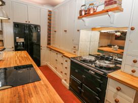 A kitchen with a fridge, oven, and cabinets at The Old Vicarage in Carmarthen