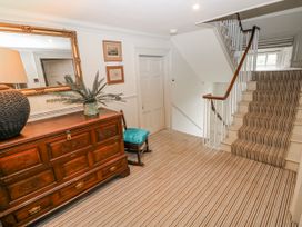 A hallway with a chest of drawers and a staircase at The Old Vicarage in Carmarthen