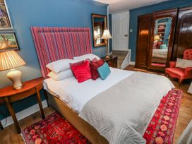 A bedroom with a bed and chair at The Old Vicarage in Carmarthen
