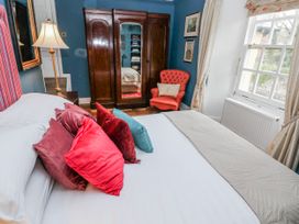 A bedroom with a bed and wardrobe at The Old Vicarage in Carmarthen