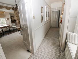A hallway with a door and photographs at The Old Vicarage in Carmarthen