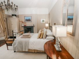 A bedroom with a bed and a chair at The Old Vicarage in Carmarthen