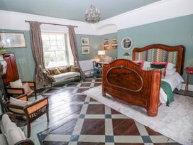 A bedroom with a bed and seating area at The Old Vicarage in Carmarthen