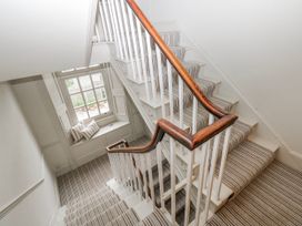 A staircase with carpet and a window at The Old Vicarage in Carmarthen