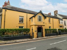 A house with yellow exterior and a hedge in front at The Old Vicarage in Carmarthen