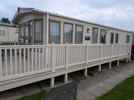 A caravan with a deck and railing at 42 Laurel Rise in Primrose Valley
