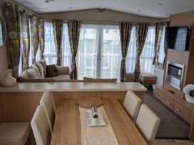 A living room with a sofa and dining table at 42 Laurel Rise in Primrose Valley