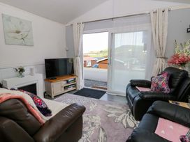 A living room with a television and sofa at The Comfort Den near Aberystwyth
