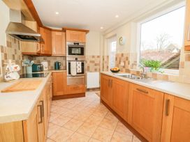 A kitchen with wooden cabinets and appliances at The Old Post Office in York
