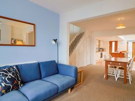 A living room with a sofa and dining area at 4 Peaslands Road in Sidmouth