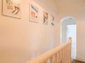 A hallway with framed posters on the wall at 4 Peaslands Road in Sidmouth